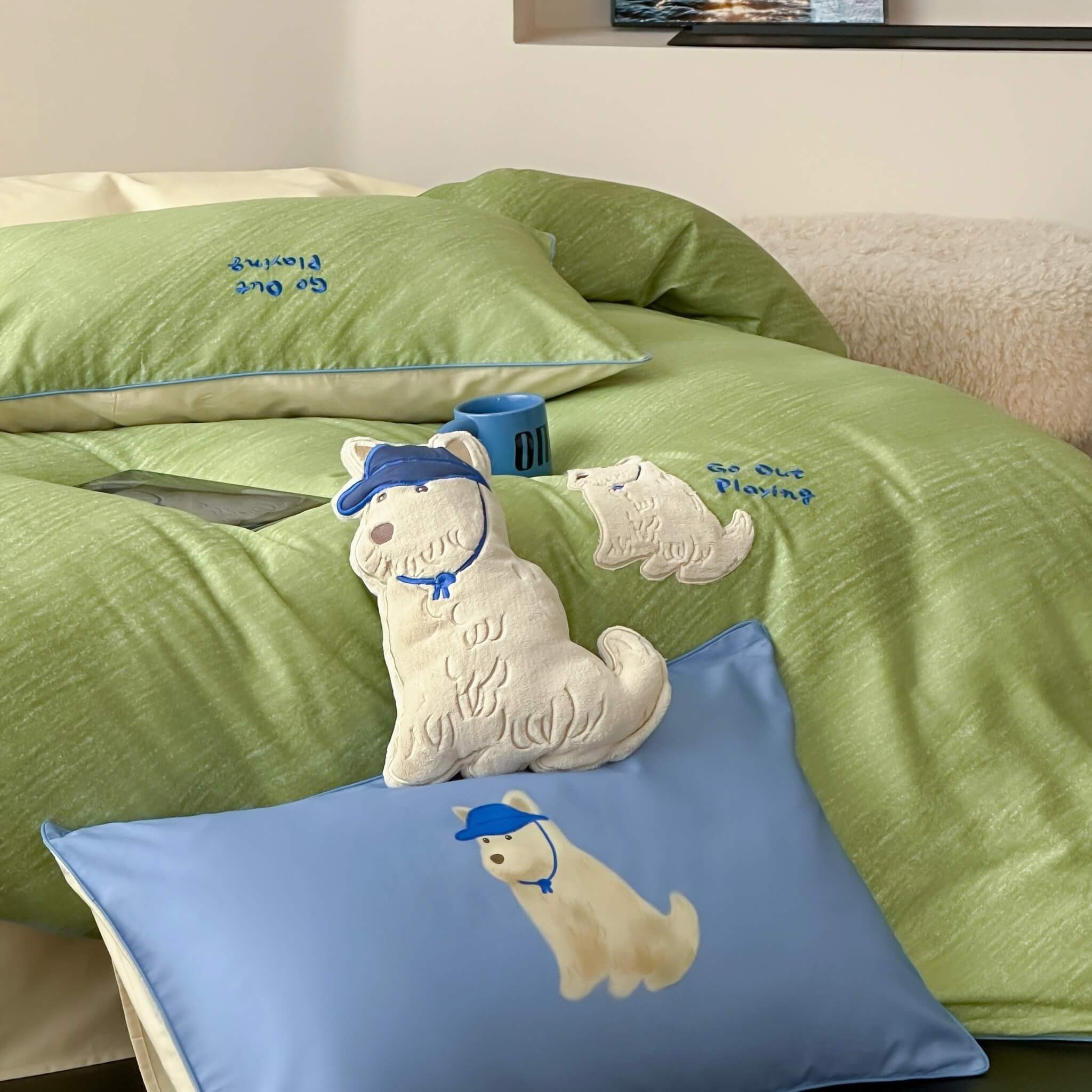 Green bedding set with dog illustrations and 'Go Out Playing' text on a bed.
