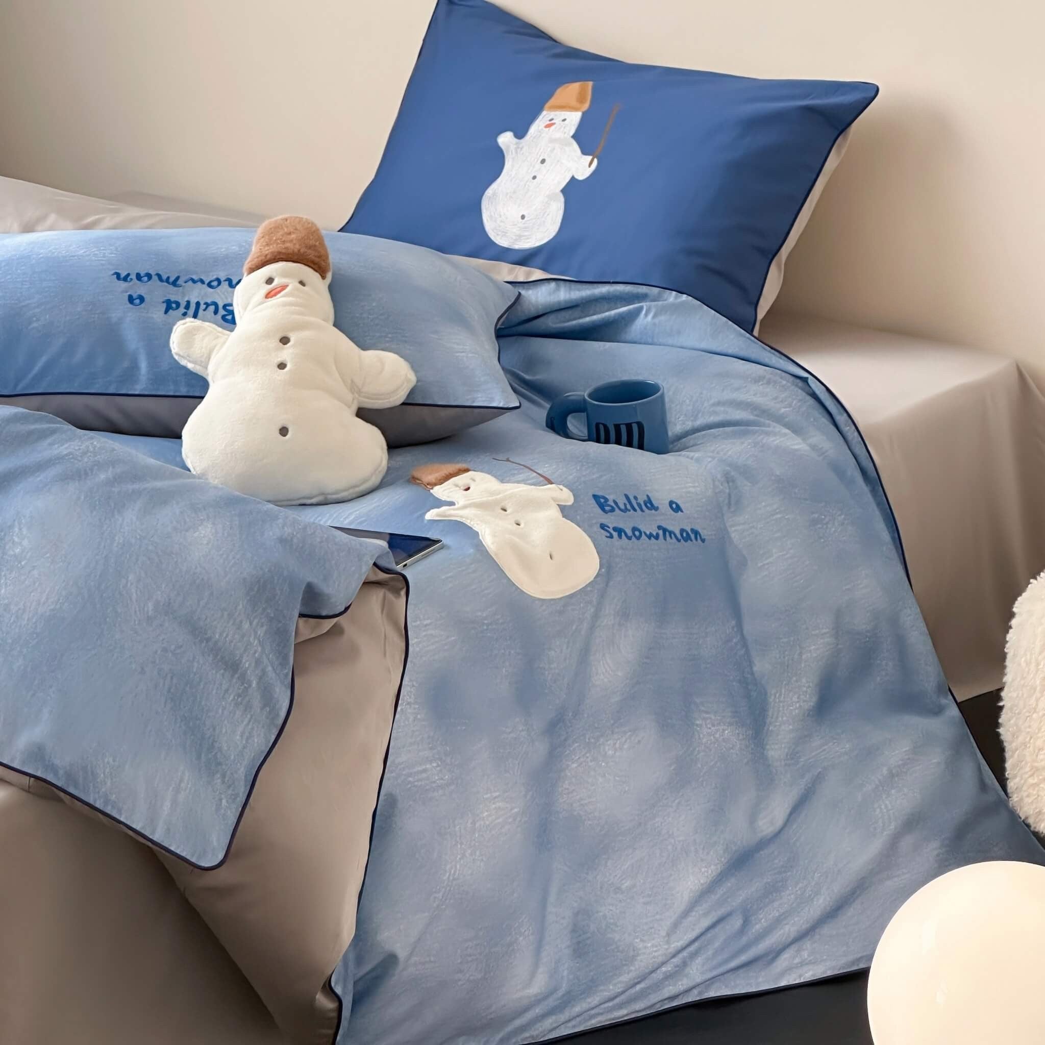 Blue bedding set with snowman design on a bed