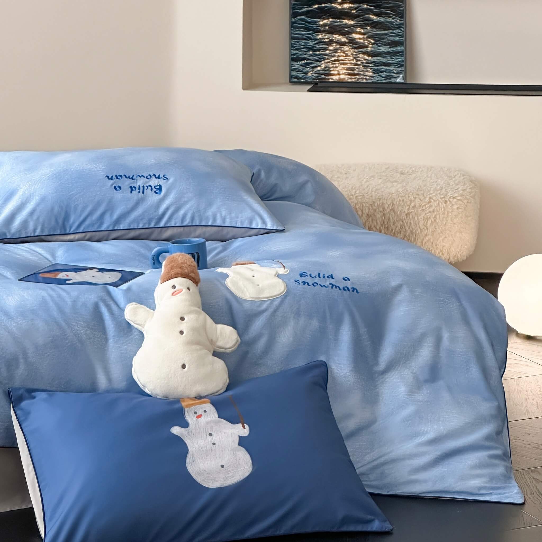 Blue bedding set with snowman design in a bedroom setting