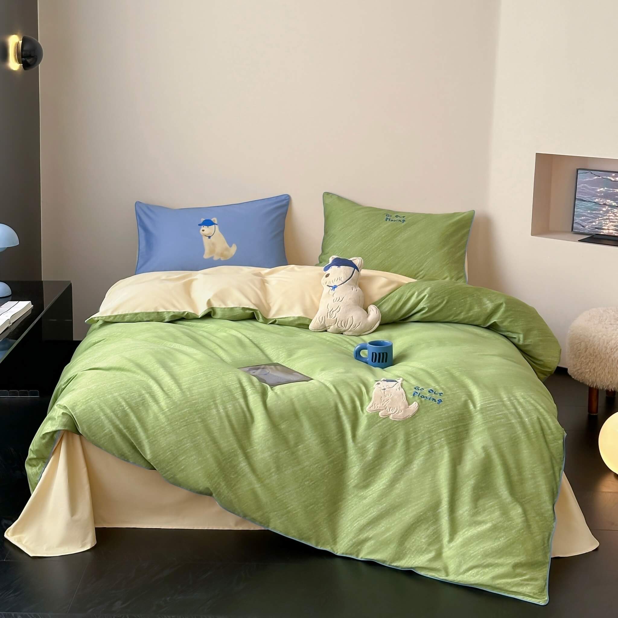 Green bedspread with embroidered dog design on a bed in a room.
