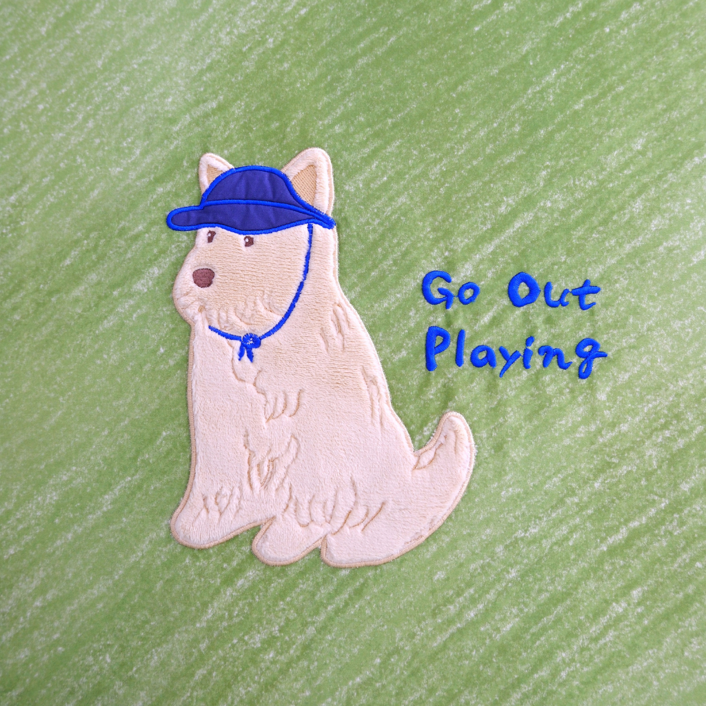 Dog pembroidery patch with a blue cap and 'Go Out Playing' text on a green background